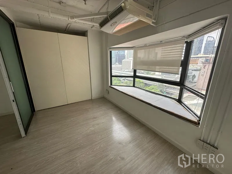 Office Space for rent in Pathum Wan, Bangkok - Compact office room with bay window, roller shades, wood flooring and Bangkok city view.