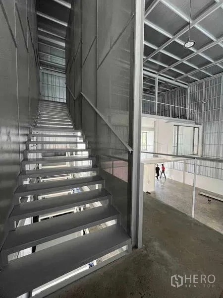 Home Office for rent or sale - Interior metal staircase beside a double-volume workspace and mezzanine.