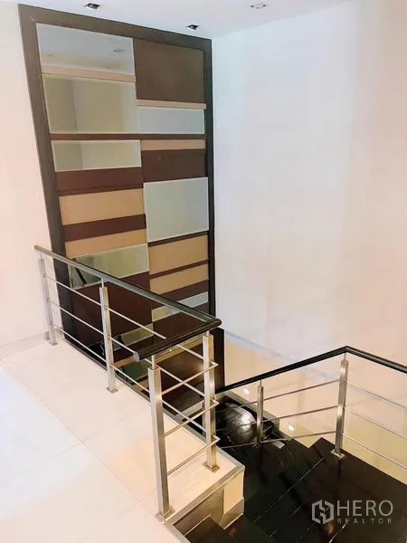 Detached House for rent or sale in Prawet, Bangkok - Staircase with metal handrails and a decorative feature shelving wall.