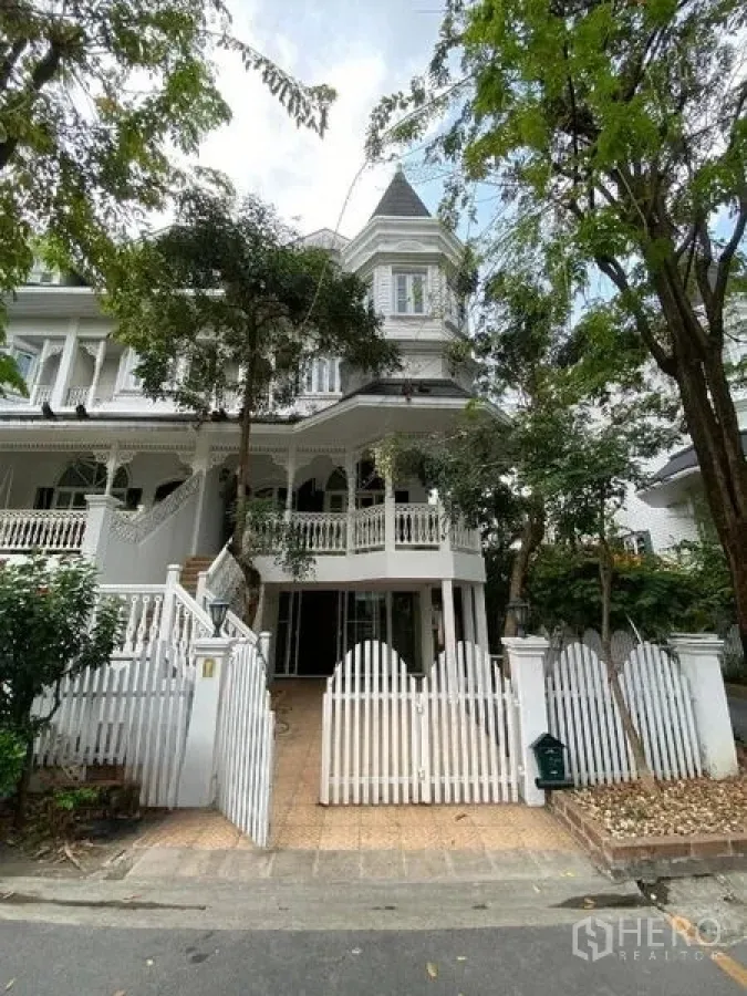 Townhouse for rent or sale in Mueang Samut Prakan, Samut Prakan - Street view of the townhouse front gate and shaded facade.