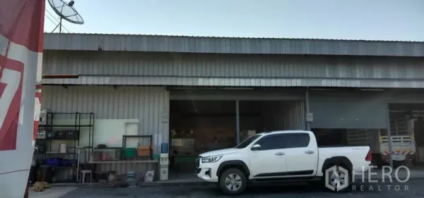货栈 出租在Khlong Sam Wa, Bangkok - 单个仓库单元入口，卷闸门开启可见内部货架，外侧停放皮卡车。