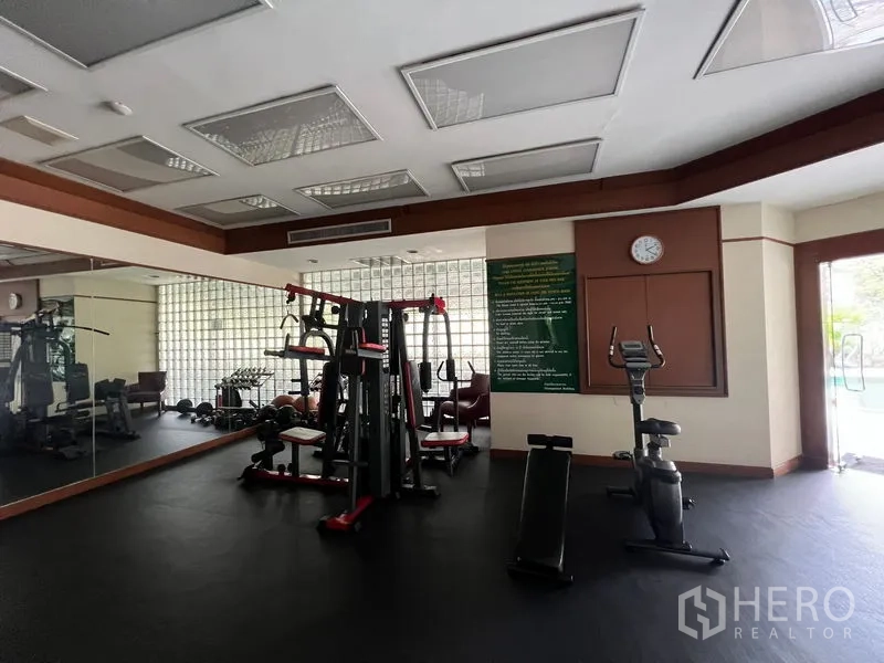 Condominium for rent or sale in Khlong Toei, Bangkok - Gym room view showing multi-gym station and exercise bike.
