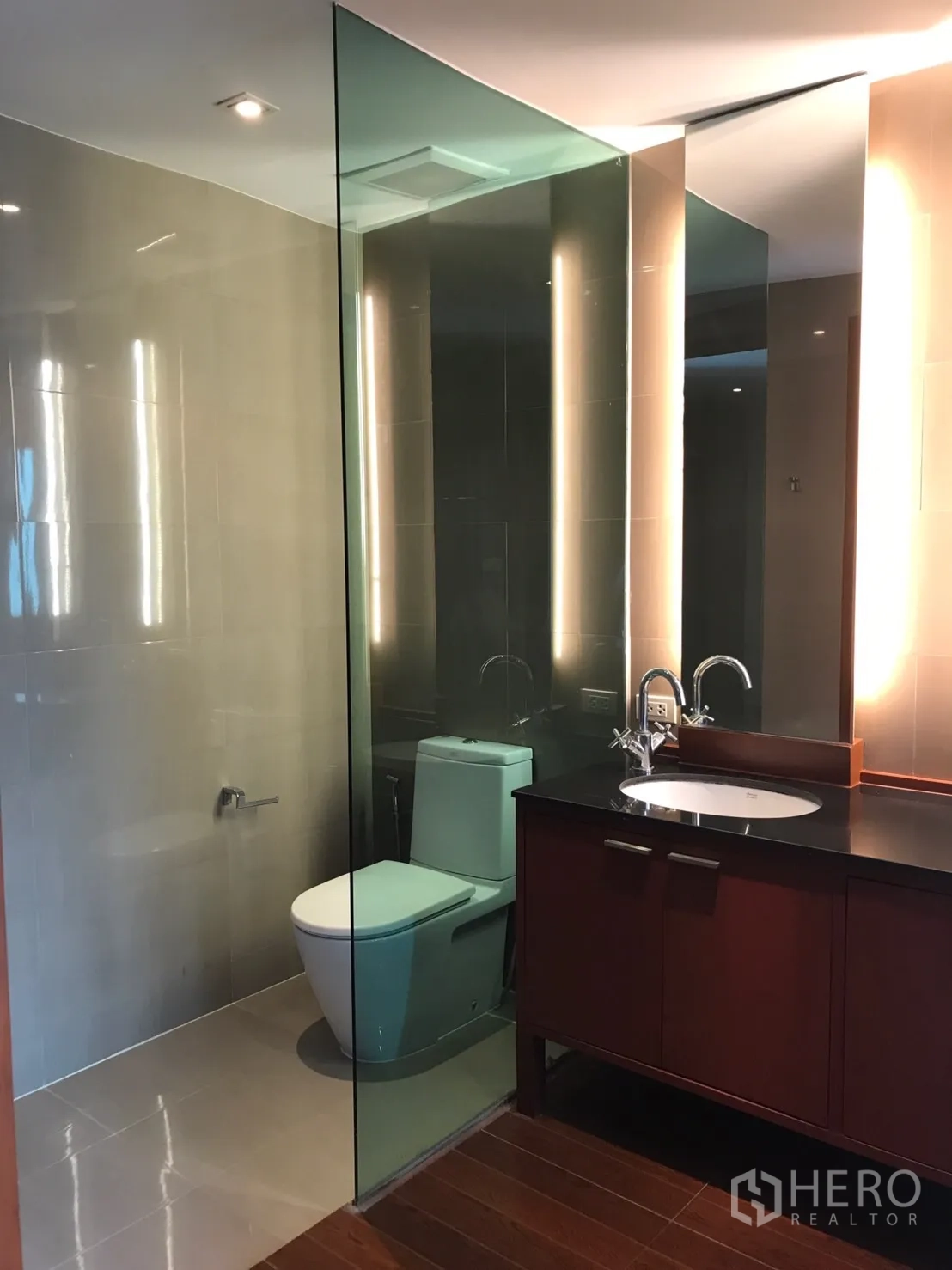 Home Office for rent in Watthana, Bangkok - Bathroom featuring a glass partition, backlit mirror and sleek fixtures.
