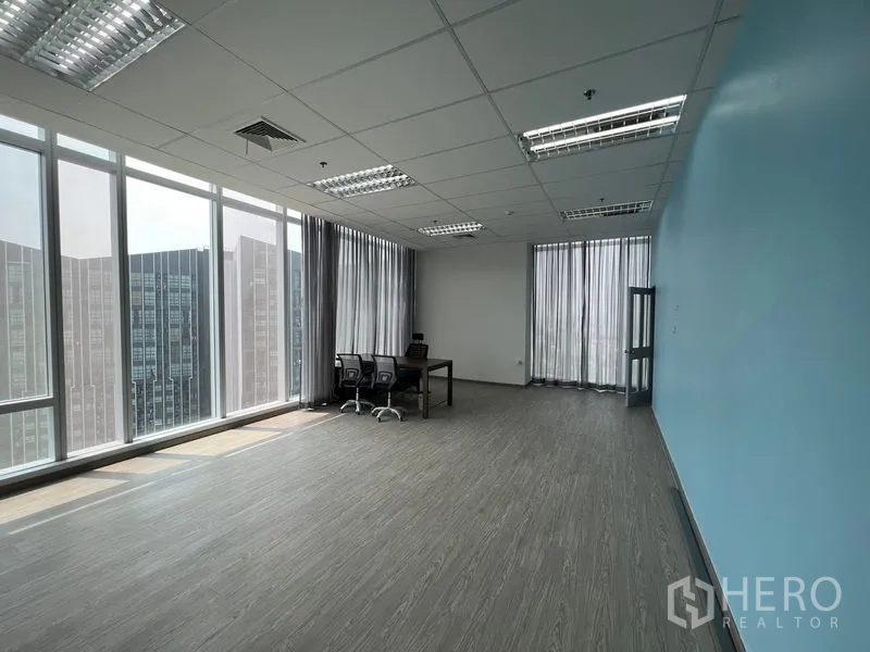 Office Space for rent - Large bright office room with blue accent wall, expansive glazing and skyline outlook.