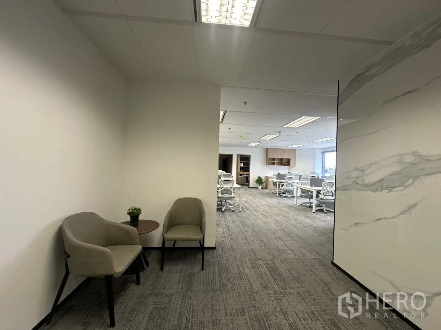 Office Space for rent in Pathum Wan, Bangkok - Waiting nook with two chairs and a side table near the open office.