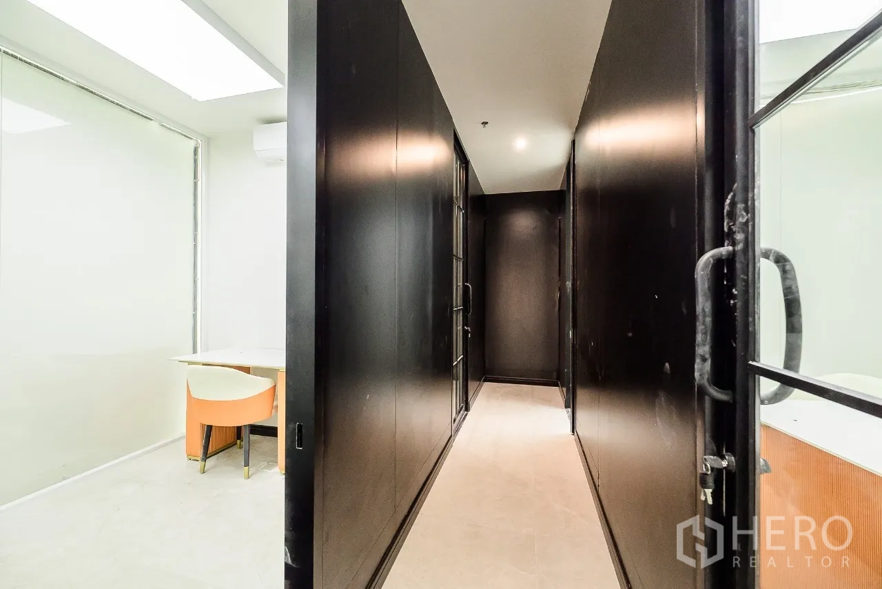 Office Space for rent or sale in Huai Khwang, Bangkok - Narrow corridor between black walls and glass partitions with downlights.