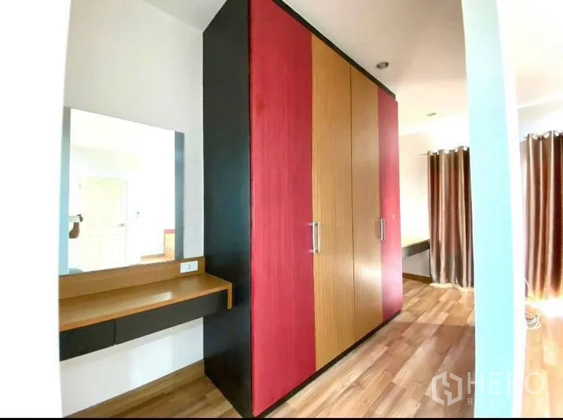 Townhouse for rent in Suan Luang, Bangkok - Wardrobe area with dressing table and full-height closets.