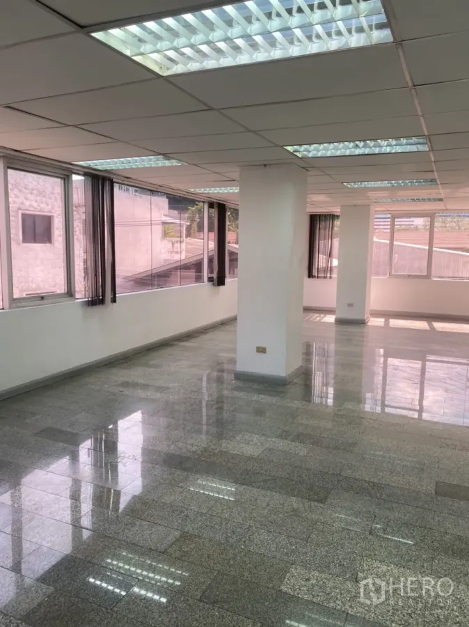 办公空间 出租在Khlong Toei, Bangkok - 通透明亮的开放式办公室，落地窗、花岗岩地面与格栅灯，临近BTS通罗站。