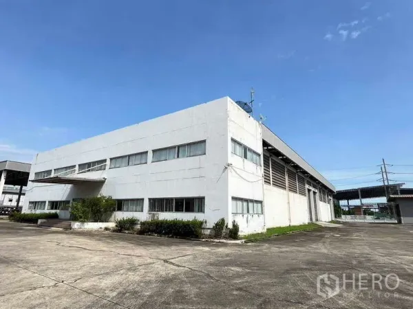 Warehouse for rent in Lat Krabang, Bangkok - Two-storey warehouse with attached office and wide driveway under clear sky in Lat Krabang Industrial Estate.