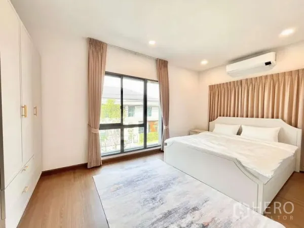 Detached House for rent in Bang Phli, Samut Prakan - Bright bedroom with king bed, large window, curtains, built-in wardrobe and rug.