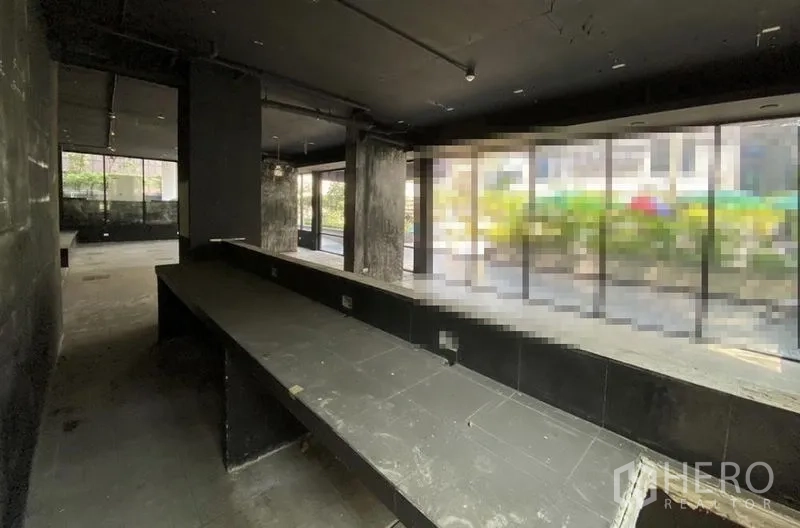 Retail Space for rent in Khlong Toei, Bangkok - Dark-shell retail unit with long service counter and floor-to-ceiling windows.