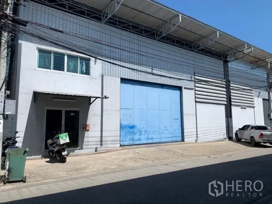 Warehouse for rent in Bang Kapi, Bangkok - Warehouse exterior in Bang Kapi with large blue sliding loading door and covered roof.