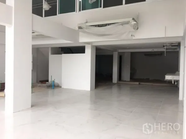 Shophouse for rent in Bang Na, Bangkok - Bright open-plan shophouse ground floor with white tile flooring, pillars and a mezzanine-ready layout near BTS Udom Suk.