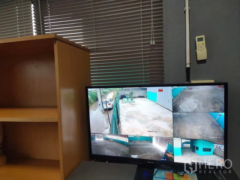 Warehouse for sale in Lam Luk Ka, Pathum Thani - Office security monitor displaying multiple CCTV camera views of the premises.