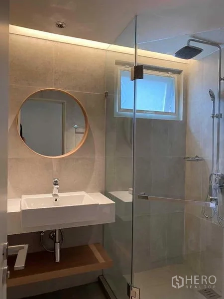 Detached House for rent in Watthana, Bangkok - Contemporary bathroom with glass shower enclosure and round mirror.