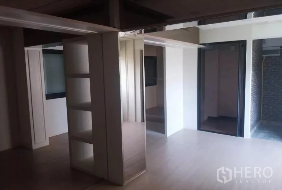 Retail Space for rent - Flexible showroom with pillar shelving, multiple doorways and a textured accent wall.