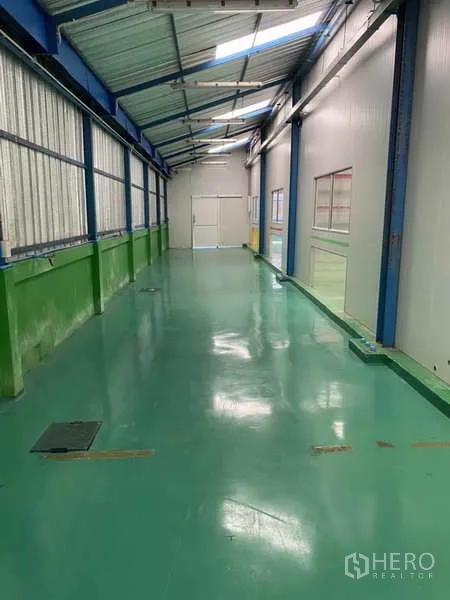 Factory for rent or sale in Bang Yai, Nonthaburi - Long corridor with epoxy floor and skylight roof connecting production zones.