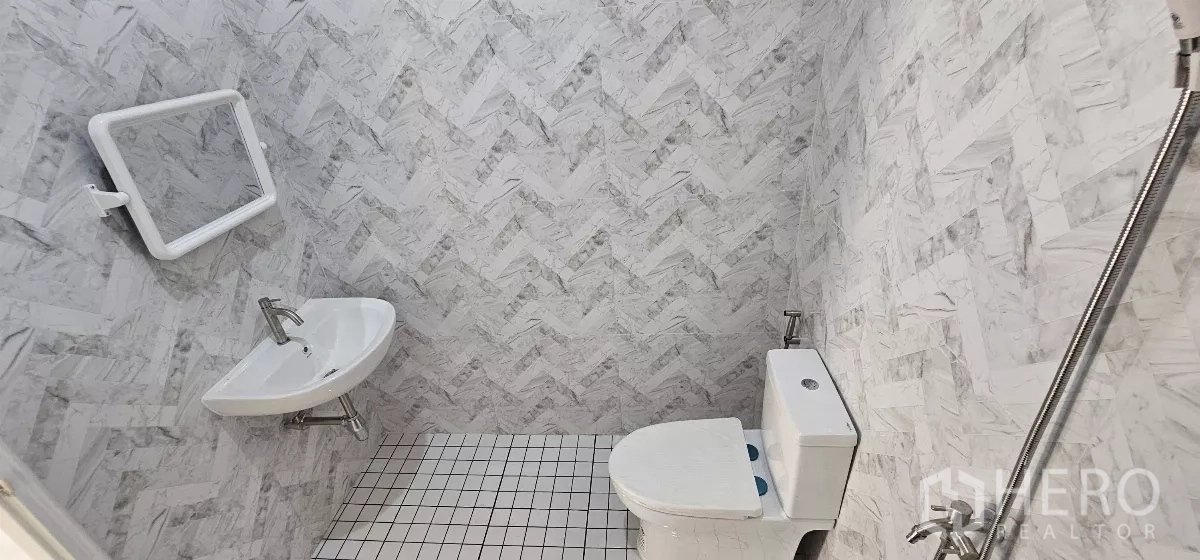 Warehouse for rent in Lat Krabang, Bangkok - Clean tiled restroom with toilet, sink and handheld shower inside the warehouse.