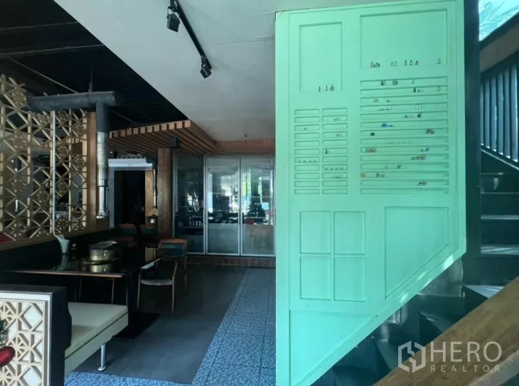 Retail Space for rent in Watthana, Bangkok - Ground floor interior showing staircase to upper level, patterned tiles, seating, and partition panels.