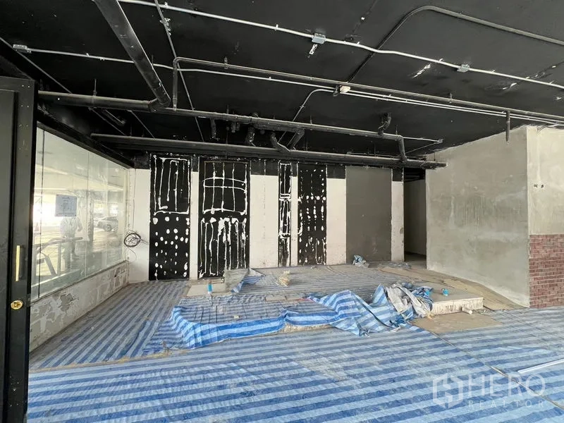 Retail Space for rent in Watthana, Bangkok - Front retail zone with high black ceiling, display platform, and floor-to-ceiling glazing.