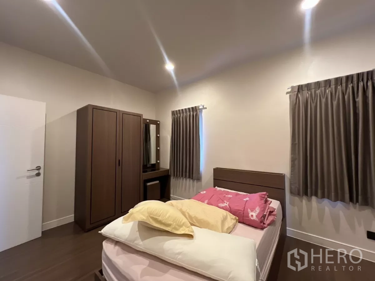 Detached House for rent in Bang Kapi, Bangkok - Furnished bedroom with bed, wardrobe, and dressing table.