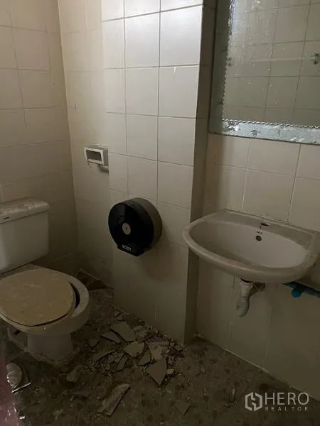 店屋 出租在Watthana, Bangkok - 白色瓷砖卫生间，配坐便器、洗手盆和镜子，适合翻新。