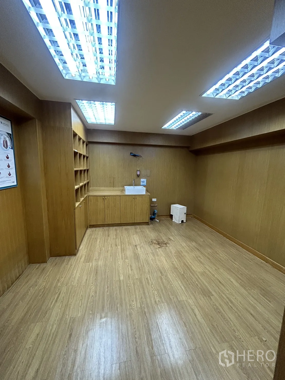 Retail Space for rent in Watthana, Bangkok - Back room featuring built-in cabinetry, bright fluorescent lights and wood-look floors.