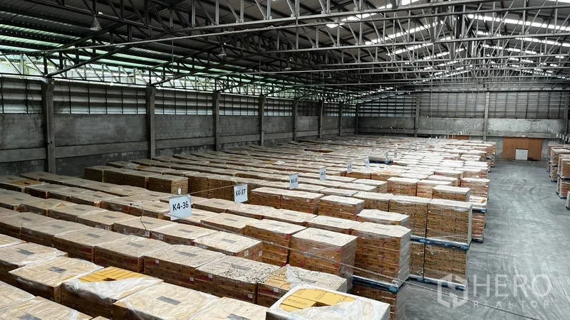 Factory for rent or sale in Pathum Thani - Panoramic view of a large warehouse with extensive pallet storage.