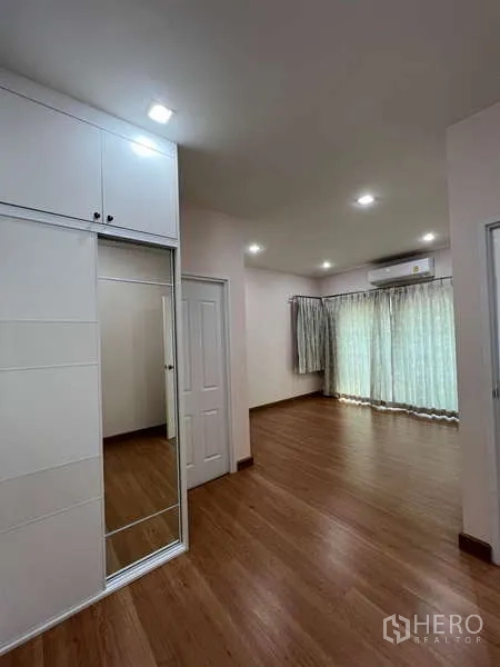 独立式住宅 出租或出售在Khan Na Yao, Bangkok - 宽敞主卧，木地板、内置衣柜与大窗。