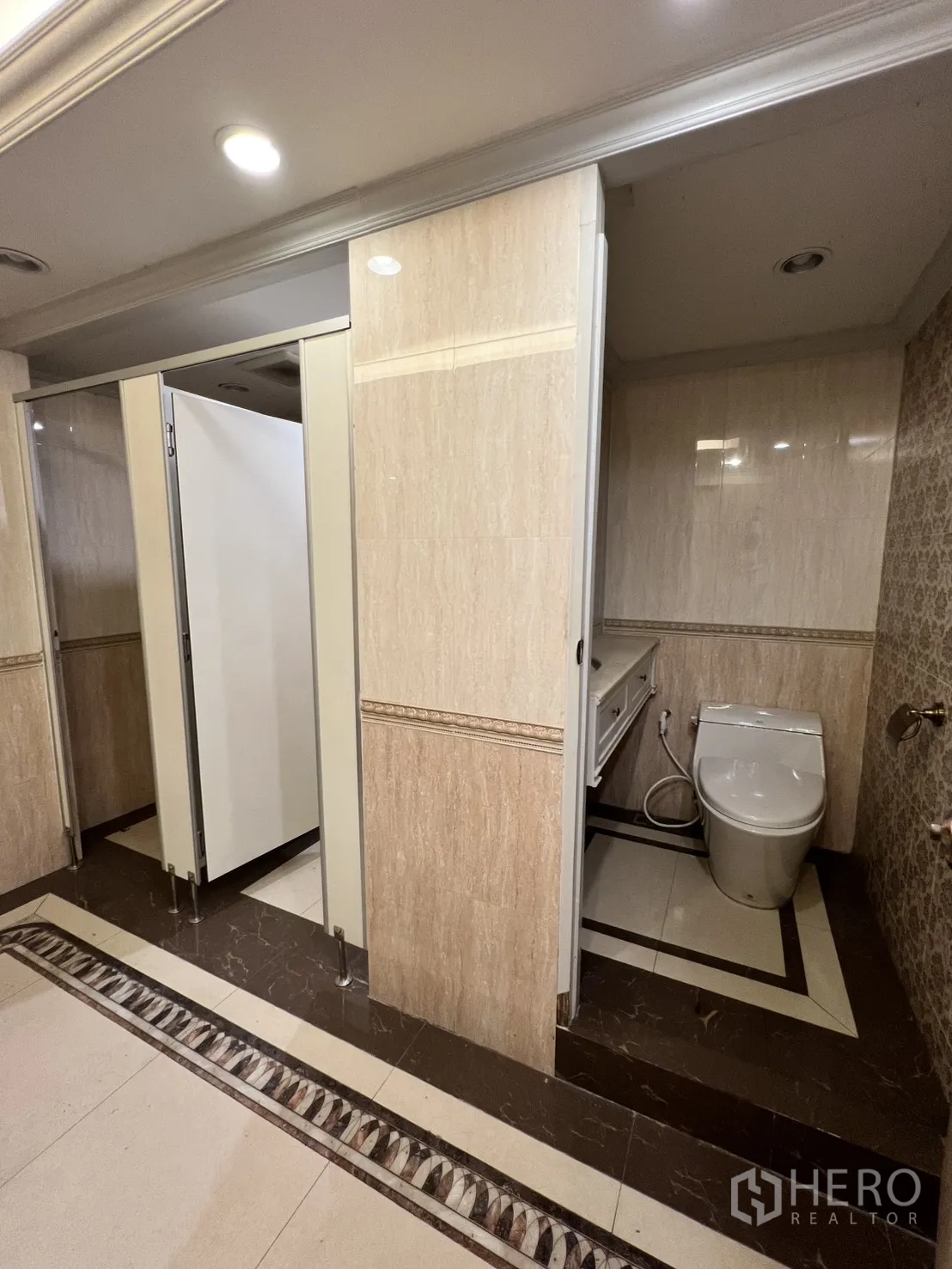 Office Space for rent in Watthana, Bangkok - Restroom stalls with modern toilet and marble-trimmed flooring.