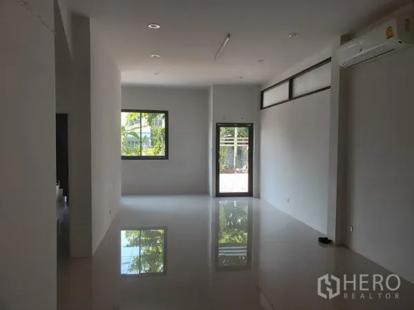Factory for rent or sale in Lam Luk Ka, Pathum Thani - Ground-floor office or showroom with glossy tile flooring, windows and split-type air conditioner.