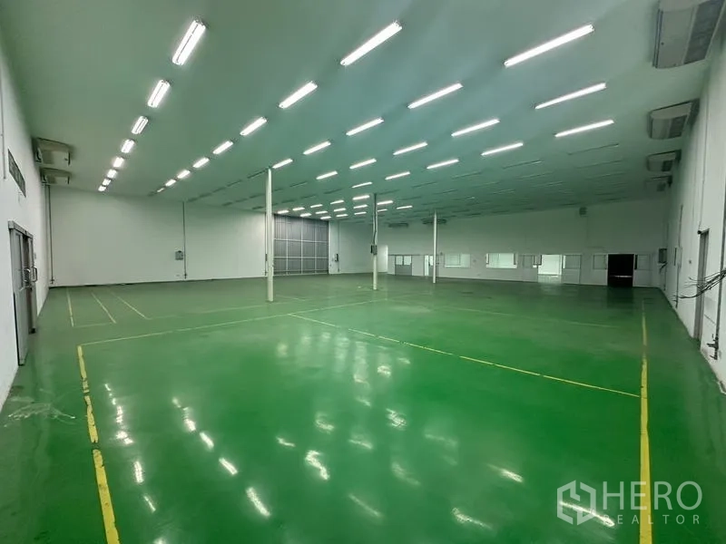 Warehouse for rent in Suan Luang, Bangkok - Angled view of a spacious warehouse with LED lighting and loading access.