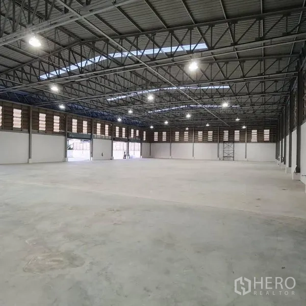 Warehouse for rent in Prawet, Bangkok - Open-plan warehouse floor with LED lighting and steel roof structure.