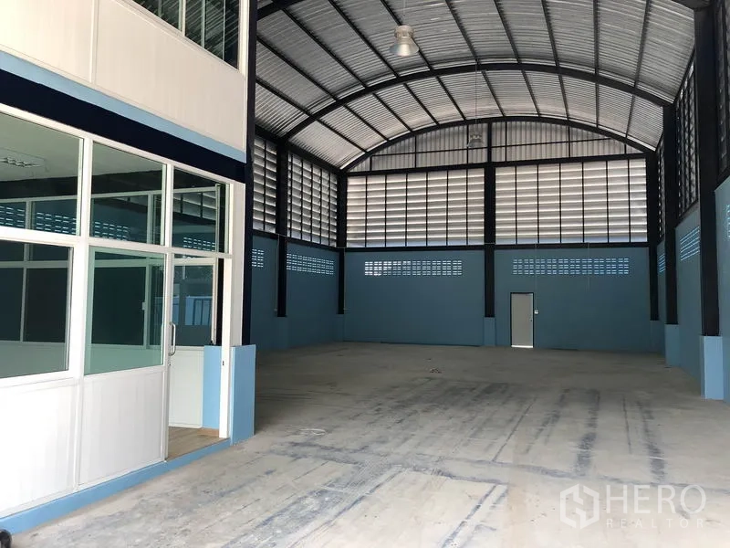 Factory for rent or sale in Bang Bua Thong, Nonthaburi - Ground-floor office entrance beside the large clear-span workshop area.