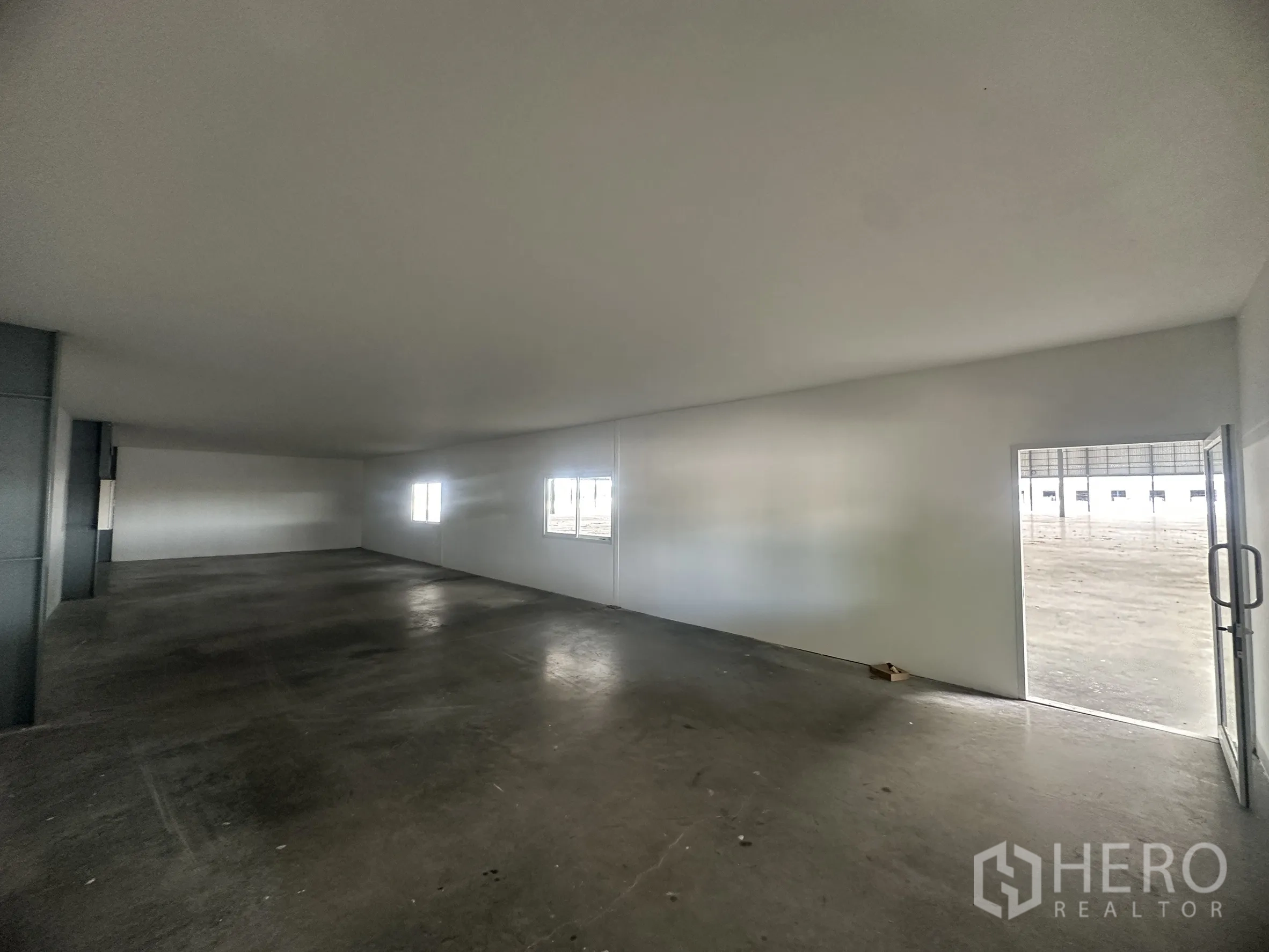Warehouse for rent in Wang Noi, Phra Nakhon Si Ayutthaya - Simple office interior with concrete floor and windows opening to the warehouse.
