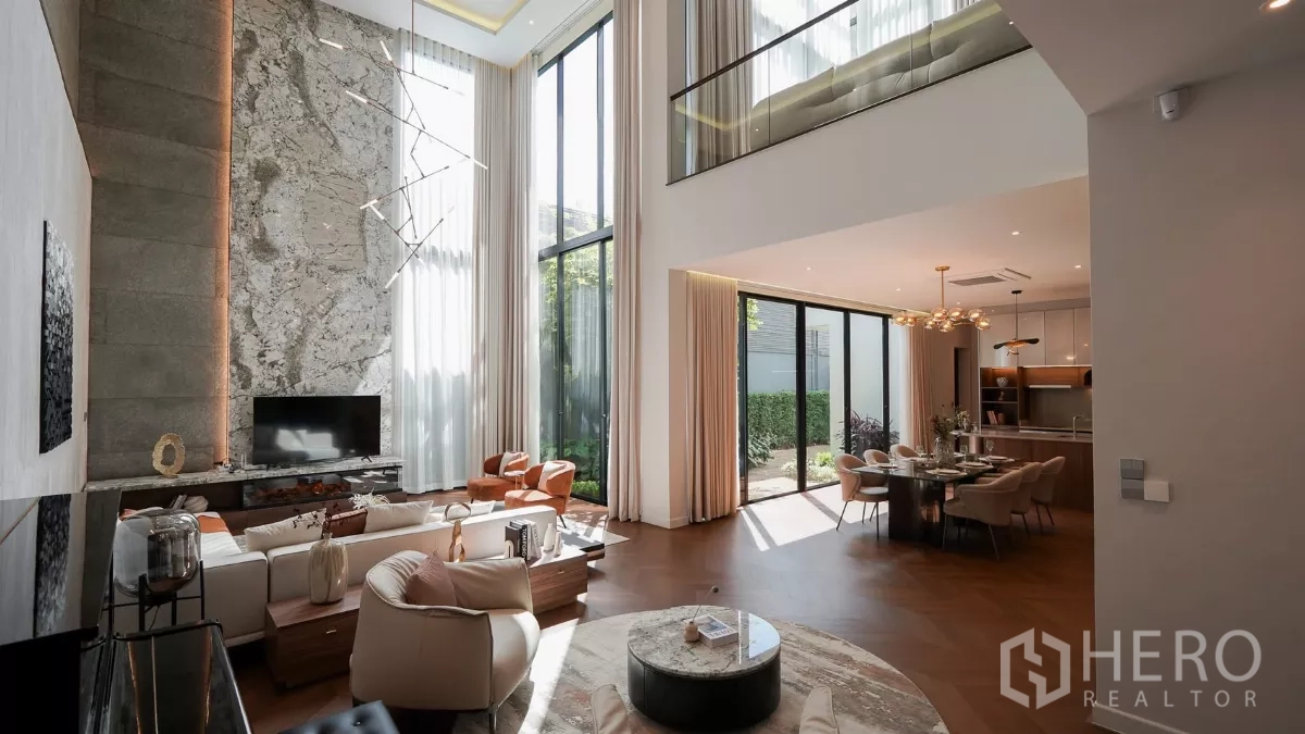 Detached House for rent or sale in Bang Kapi, Bangkok - Open-plan living and dining with floor-to-ceiling windows opening to a private garden.