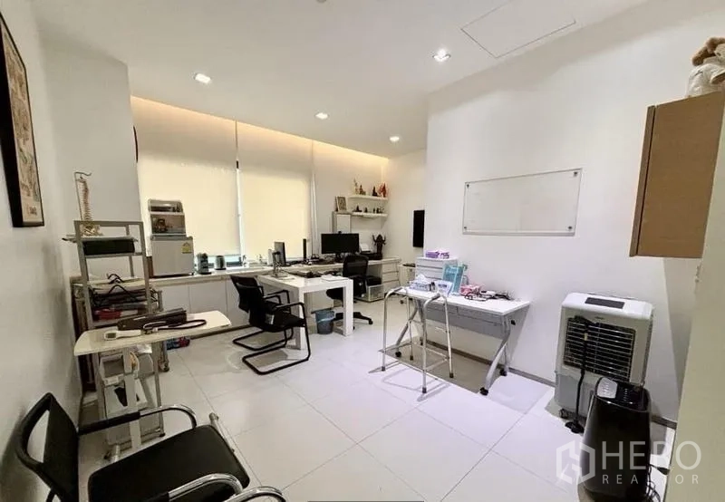 Home Office for rent in Watthana, Bangkok - Bright office room with desks, shelving and white tile flooring.