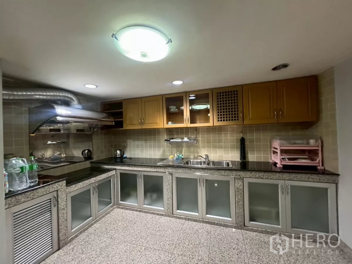 Shophouse for rent in Bang Rak, Bangkok - Full kitchen with L-shaped granite worktops, cooker hood and ample cabinets.