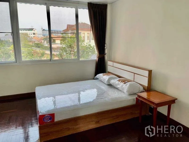 带办公室的家 出租或出售在Watthana, Bangkok - 卧室配大床与大面积窗户，可观社区景观。