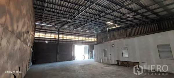 Warehouse for rent in Sathon, Bangkok - Open-plan warehouse showing wide loading entrance, skylight band and internal office block.