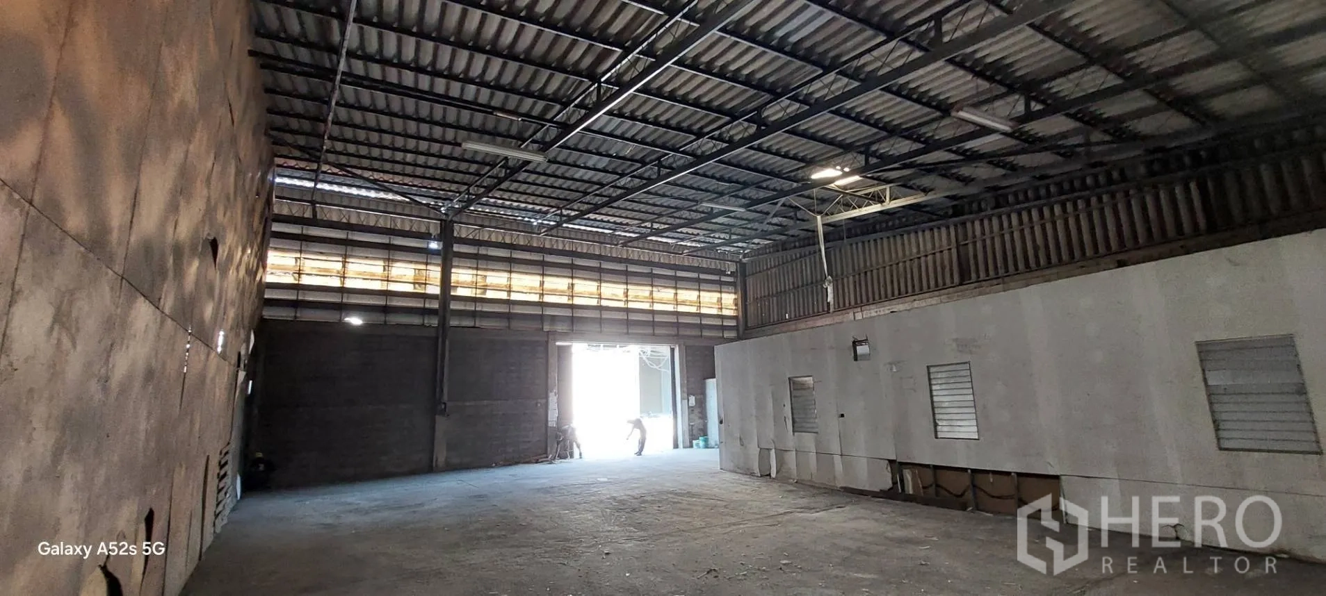Warehouse for rent in Sathon, Bangkok - Open-plan warehouse showing wide loading entrance, skylight band and internal office block.