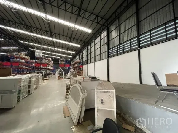 Warehouse for rent in Lat Krabang, Bangkok - Bright LED-lit aisle with elevated loading platform and storage racks inside the warehouse.