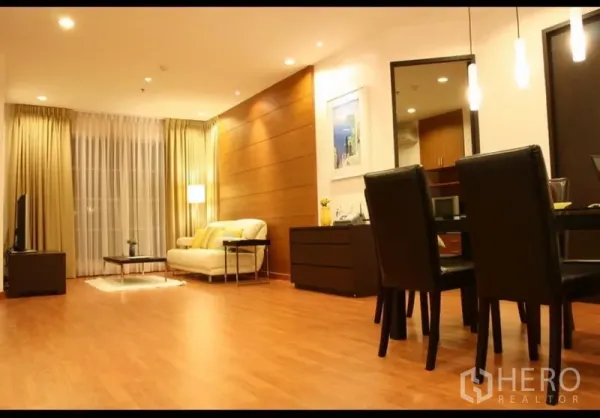 Condominium for rent or sale in Khlong Toei, Bangkok - Open-plan living and dining room with recessed lighting and floor-to-ceiling curtains.