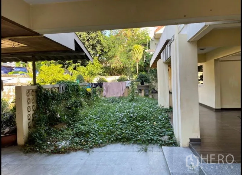 Detached House for rent in Khlong Toei, Bangkok - Inner courtyard with overgrown lawn and covered walkways connecting the house.