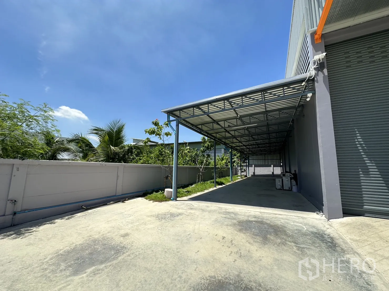 Factory for sale in Lam Luk Ka, Pathum Thani - Long covered loading or parking bay beside the factory.