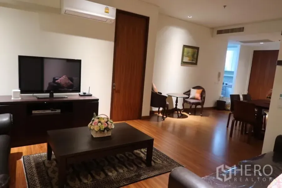 Condominium for rent in Khlong Toei, Bangkok - Cozy living room with TV console, coffee table, area rug and air-conditioning.