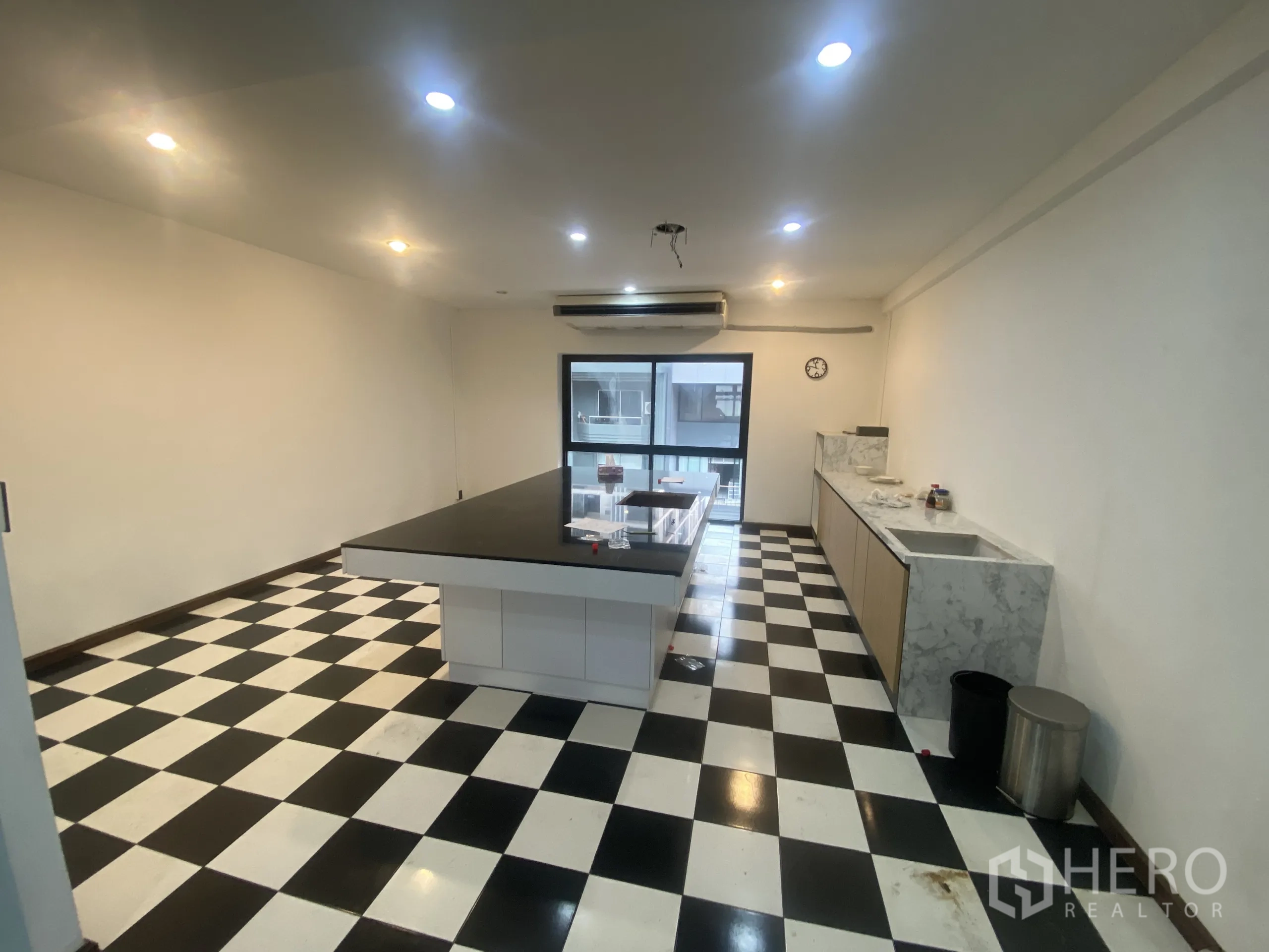 Retail Space for rent in Watthana, Bangkok - Service kitchen with black-and-white checkered floor, central island counter, sink and storage.