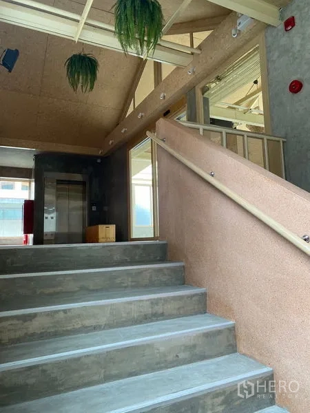 Retail Space for rent in Watthana, Bangkok - Interior stairwell with concrete steps, handrail and lift access in a minimalist atrium.