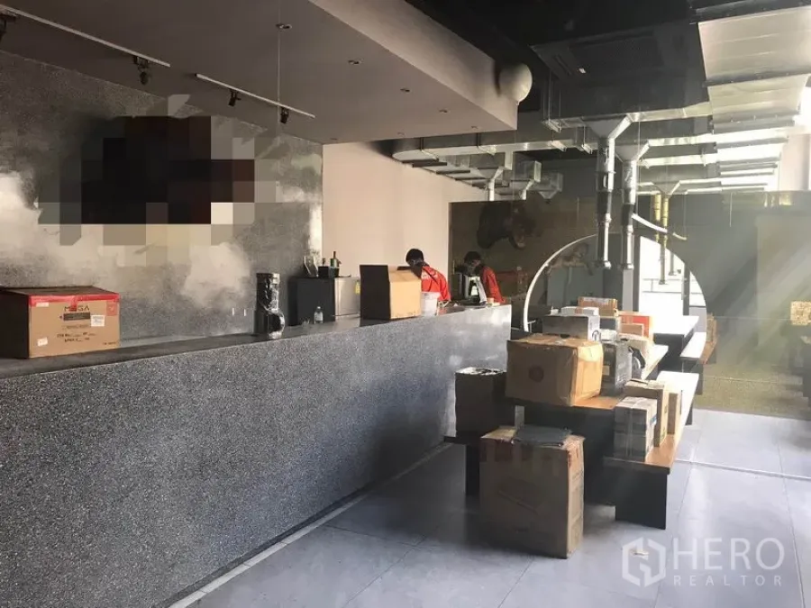 Retail Space for rent in Watthana, Bangkok - Industrial-style retail interior with a long stone counter, exposed ducting and package boxes.