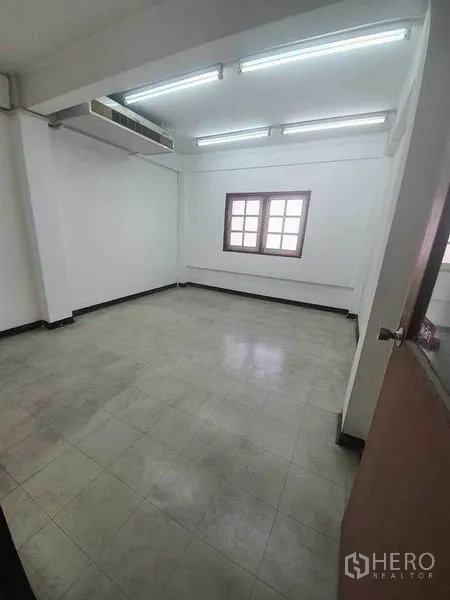 Shophouse for rent in Bang Rak, Bangkok - Spacious room with window, tiled floor and ceiling-mounted air-conditioning duct.